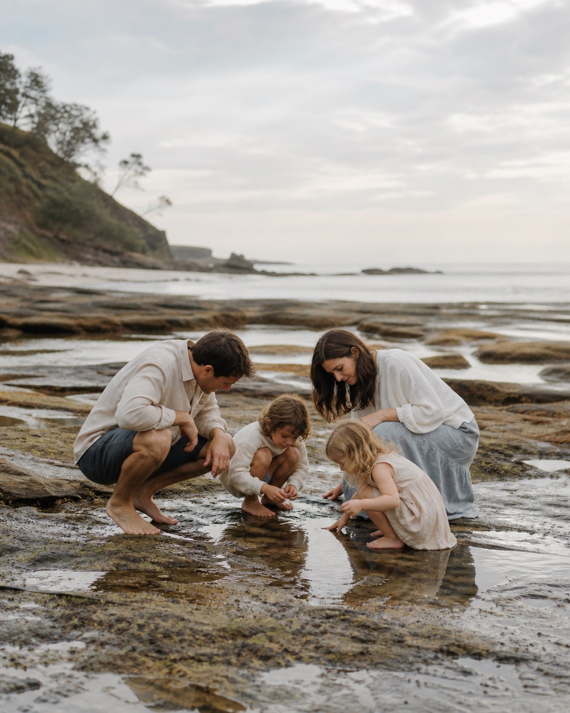Family exploring rock pools together in the morning
