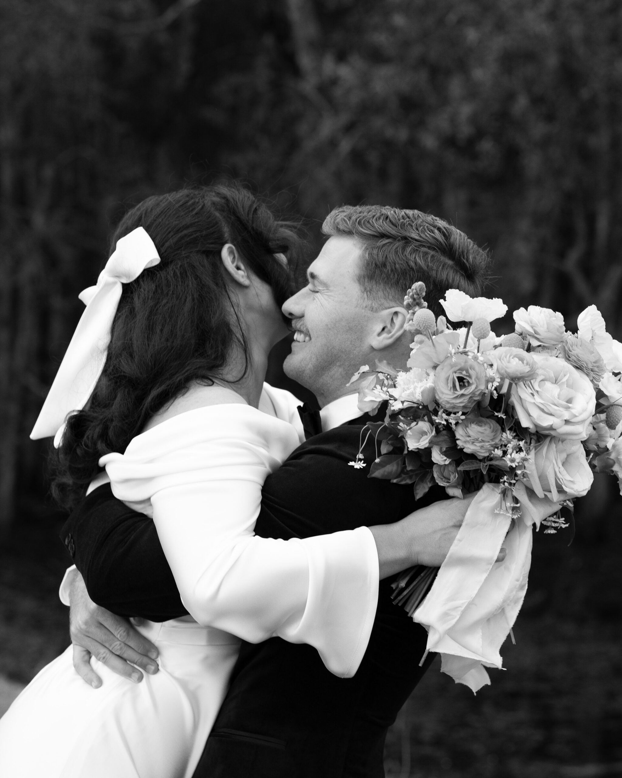 Newlyweds laughing as guests celebrate after their garden ceremony